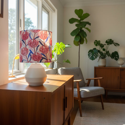 Modern living room with wooden desk, floral-patterned lampshade, and plants.