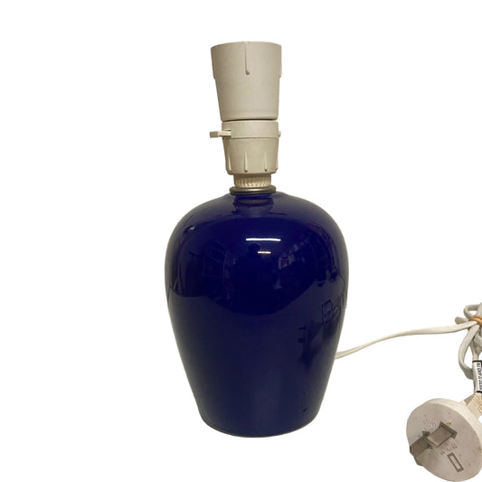 Blue ceramic lamp with white base on a light-colored surface