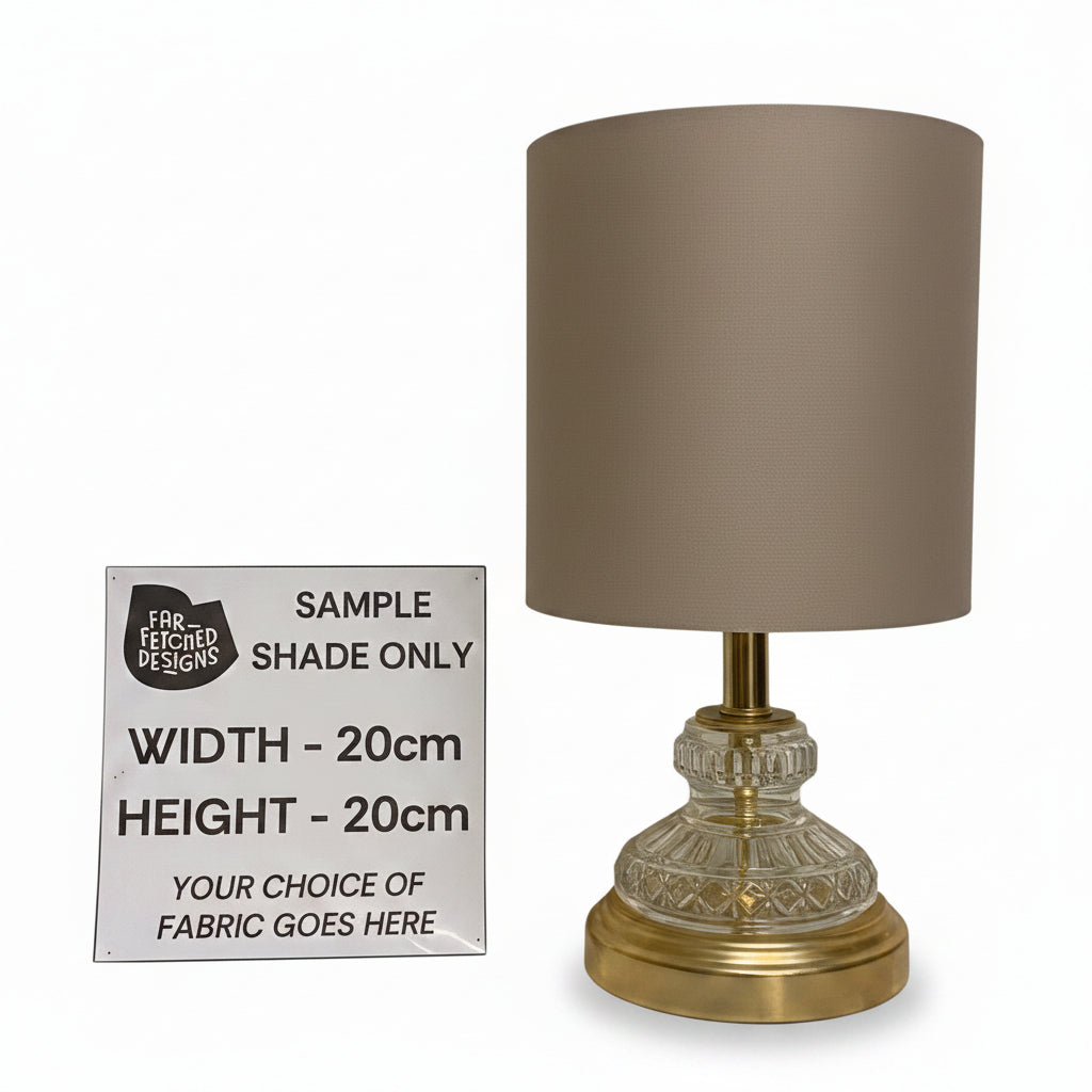Table lamp with a sample shade size sign on a white surface.