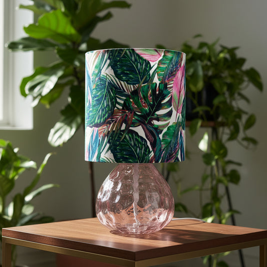 Table lamp with a tropical leaf patterned shade on a table in a home