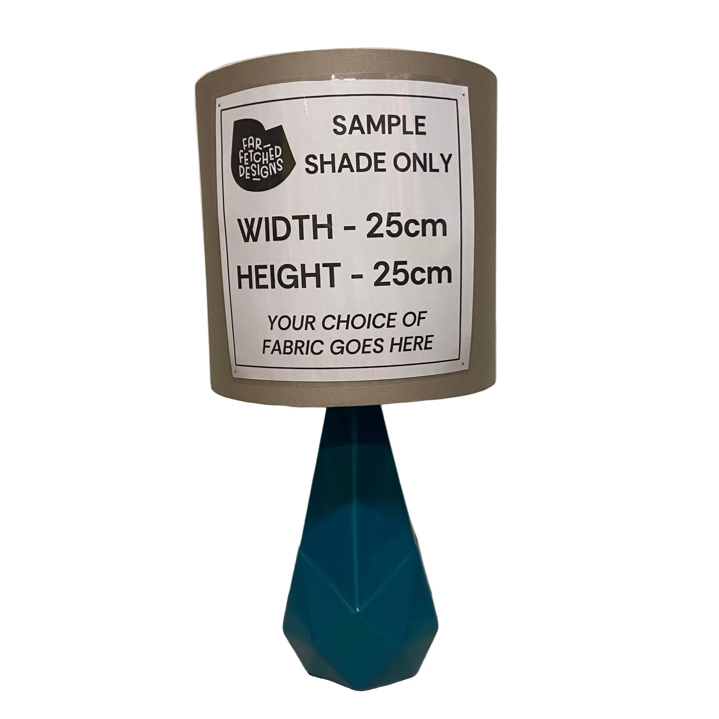 Sample lampshade with a label indicating dimensions and fabric choice options on a white background.