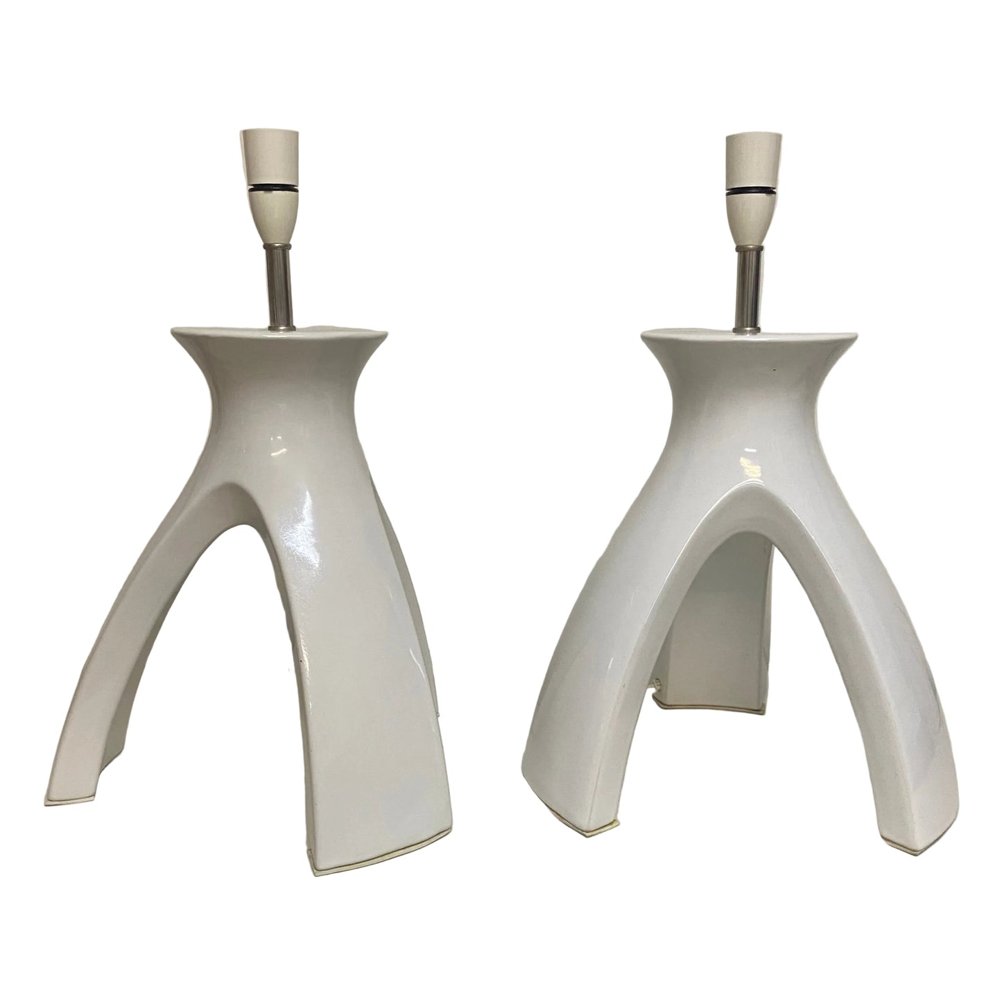 Two white ceramic table lamps on a white surface with a neutral background.