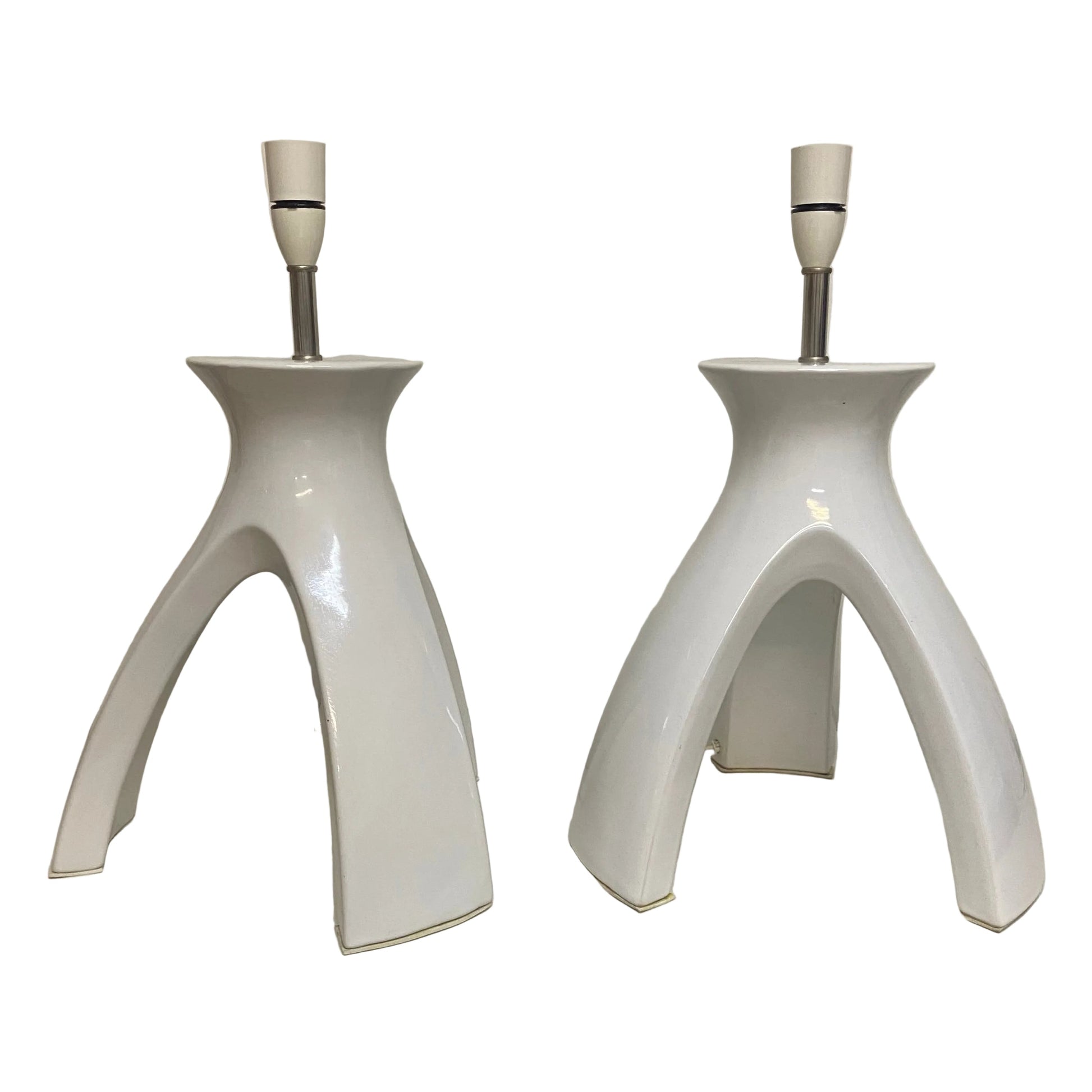 Two white ceramic table lamps on a white surface with a neutral background.