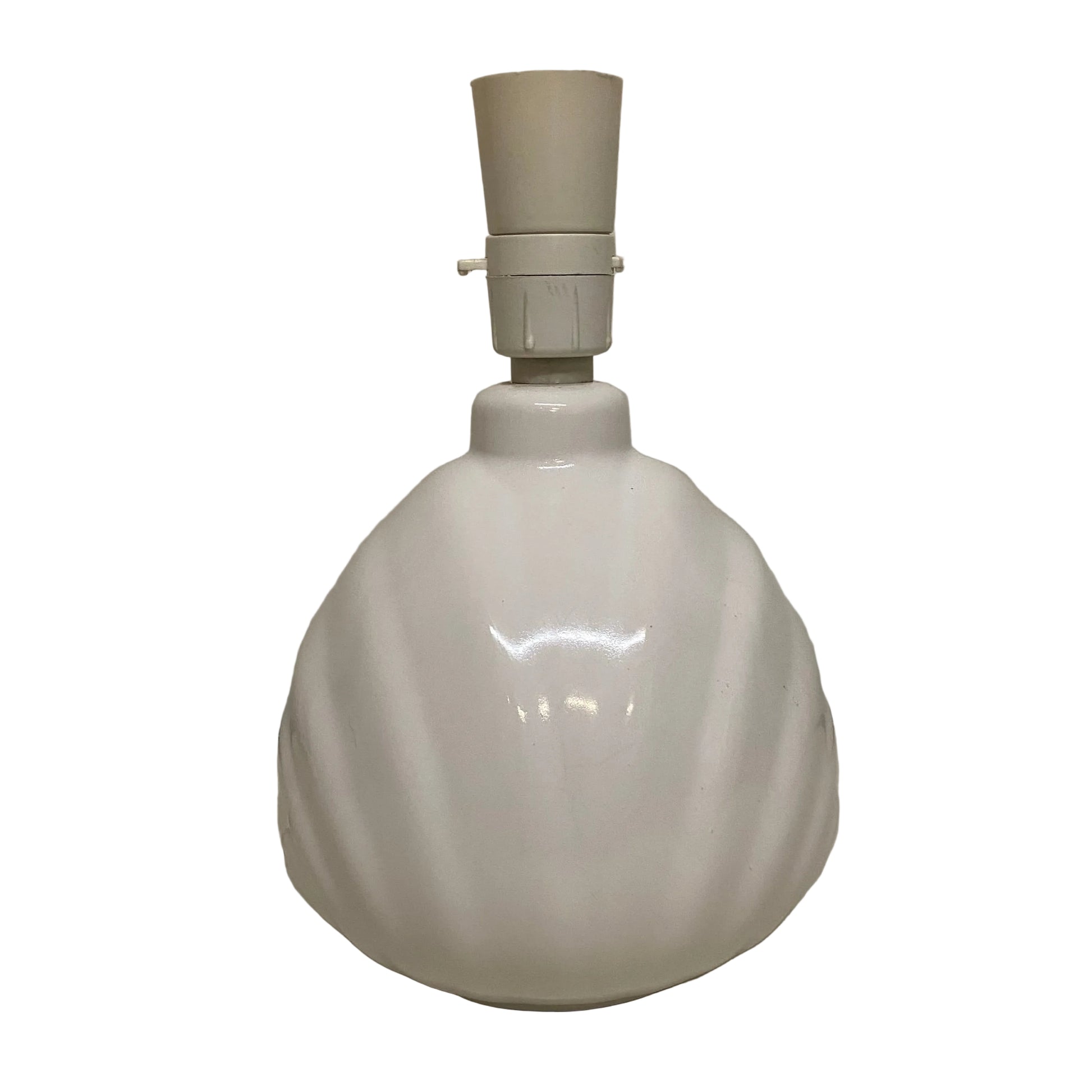 White ceramic lamp base with beige lampshade on a plain surface.