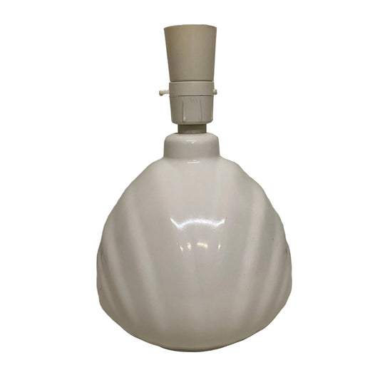 White ceramic lamp base with beige lampshade on a plain surface.
