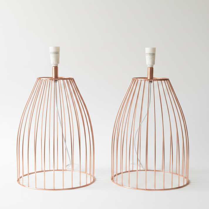Two matching copper wire cage table lamps with white sockets, photographed on a clean white background.