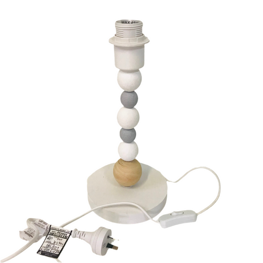 A table lamp with a timber base and a fabric shade featuring a geometric pattern, placed on a white surface.