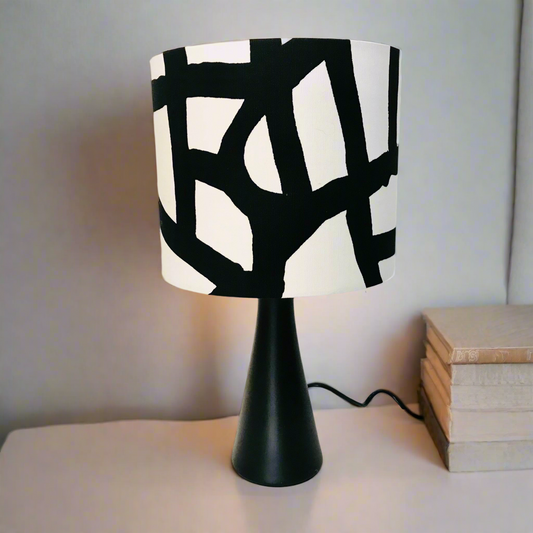 Table lamp with a black and white patterned shade on a neutral background