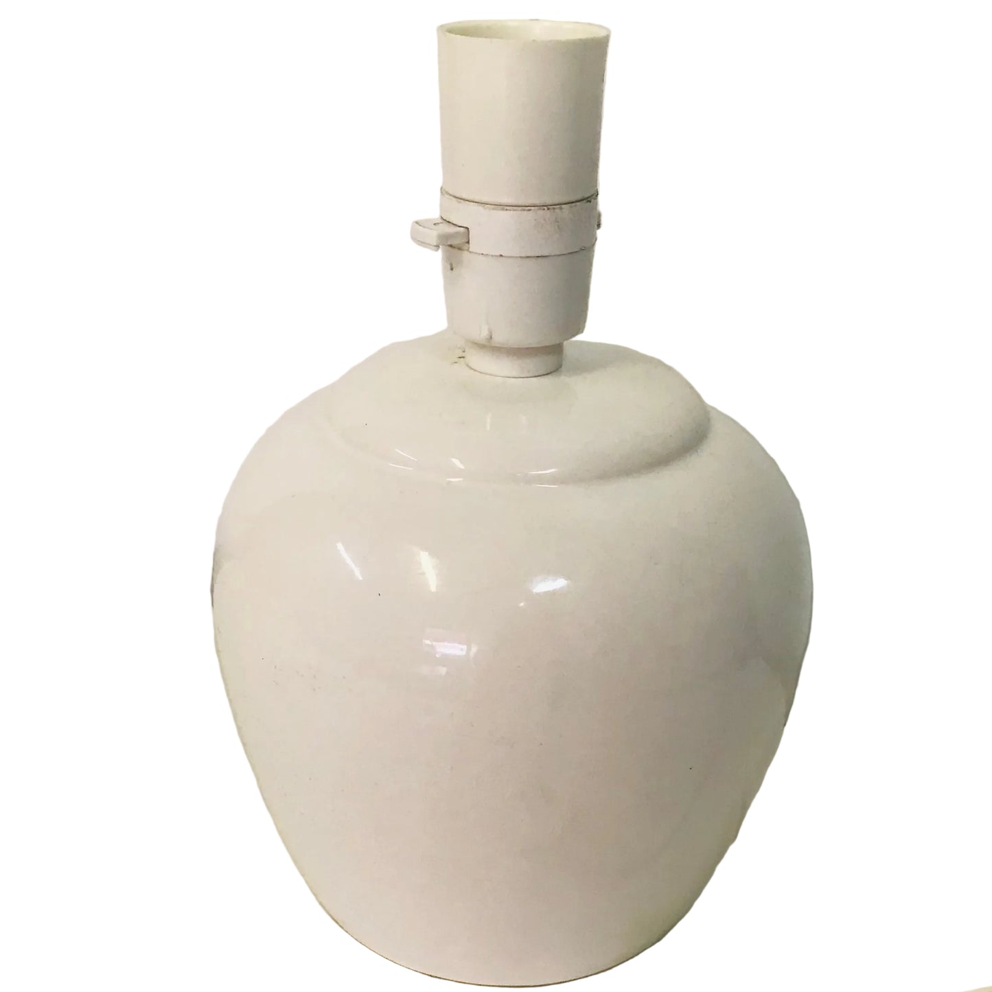 White ceramic lamp with a visible plug on a light-colored surface.
