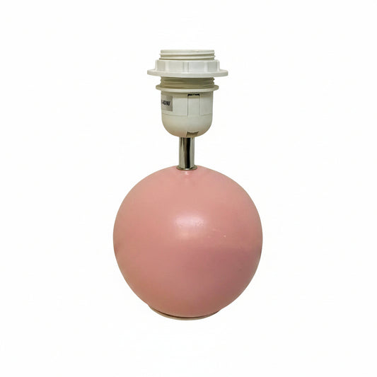 A pink spherical lamp base with a white threaded socket and metal stem, photographed against a plain off-white wall and floor.
