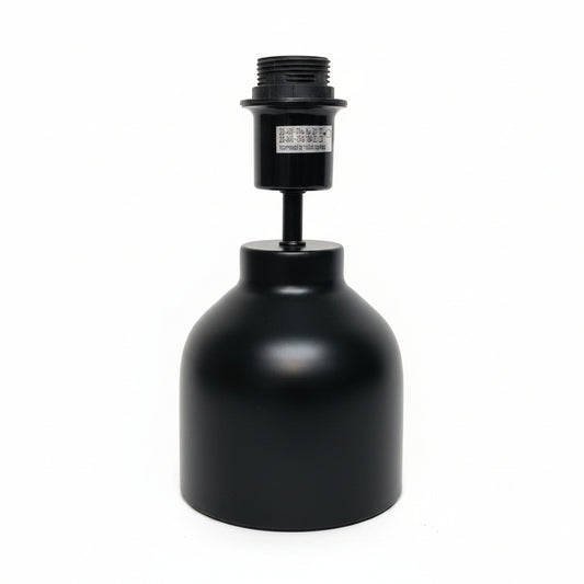 A black metal lamp base or light fixture component with a cylindrical shade-like body and threaded top, photographed against a plain off-white wall and surface.