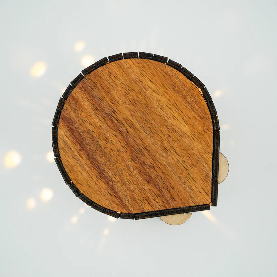 Wooden half-moon shelf with black trim on a light gray background