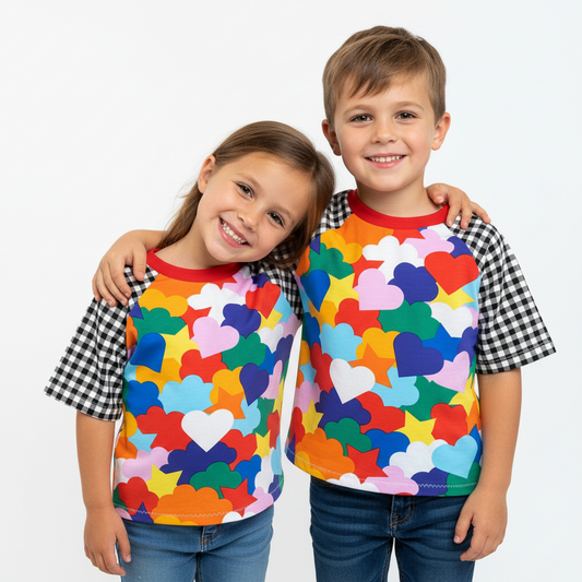 Two children wearing colorful shirts with heart patterns on a white background