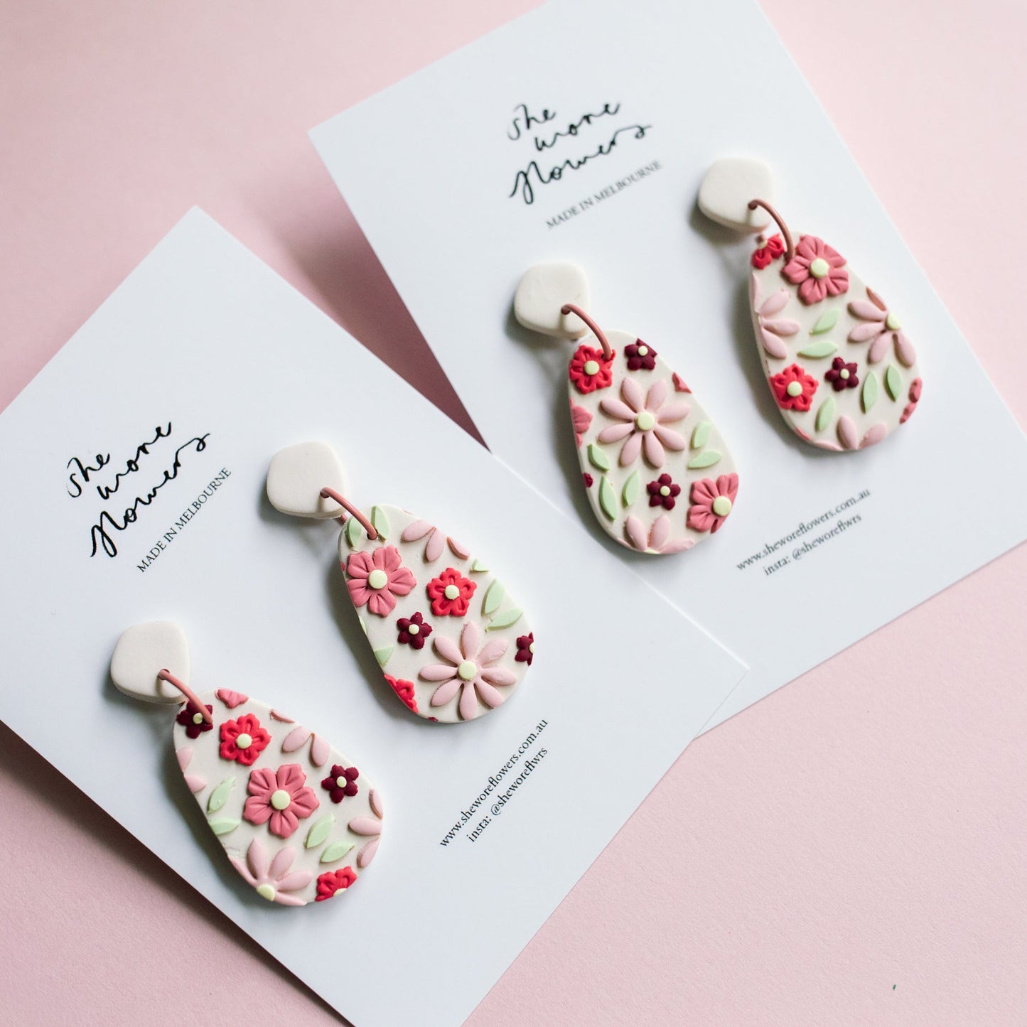 Decorative earrings with floral patterns on a pink background