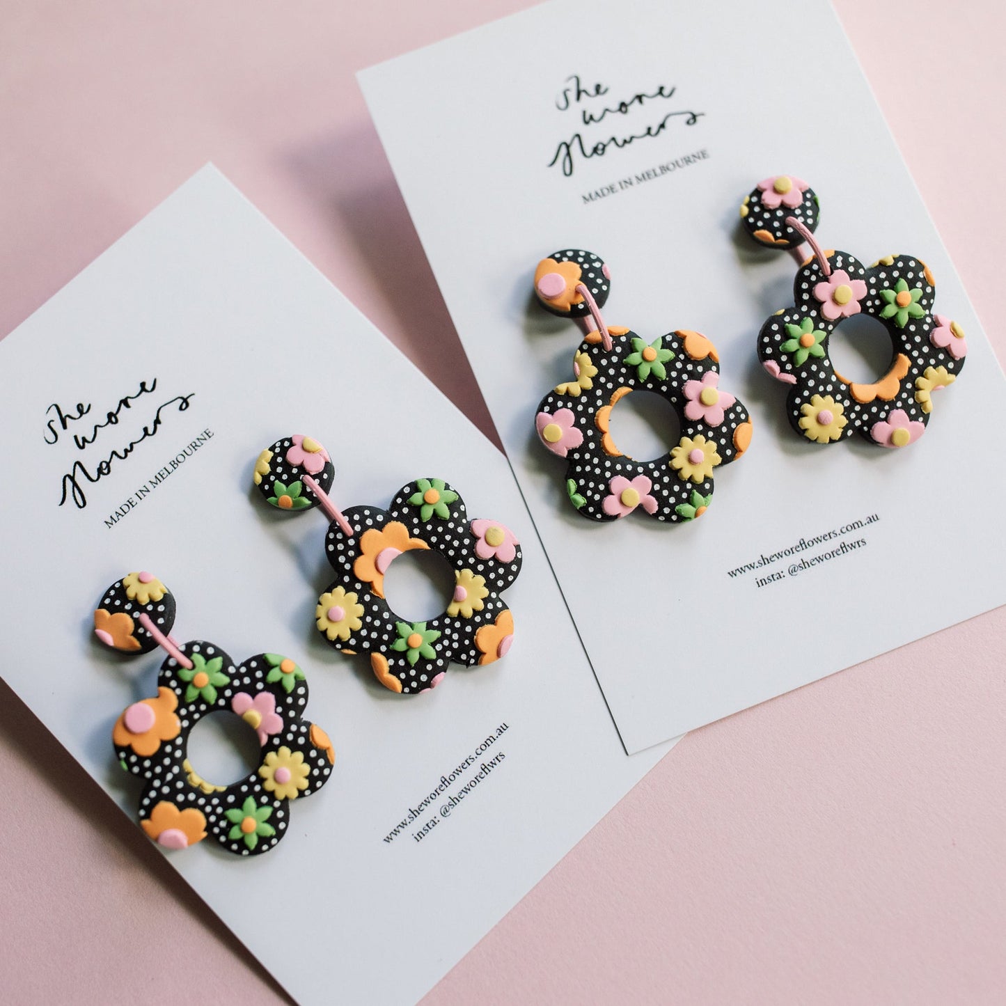 Decorative earrings on a card with 'The Anne Flowers' branding on a pink background
