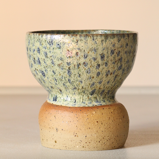 Speckled ceramic bowl on a beige background