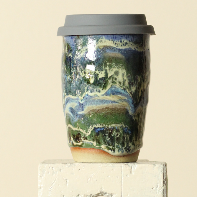 Travel mug with a scenic design on a beige background