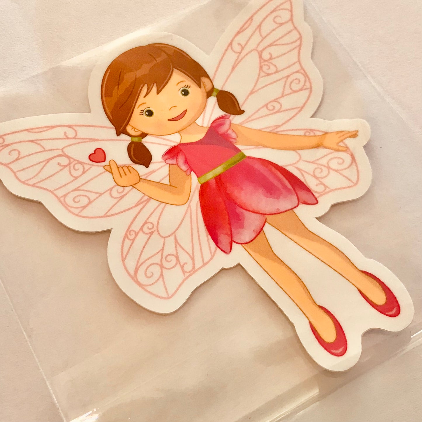 Illustration of a fairy with pink dress and red shoes on a beige background