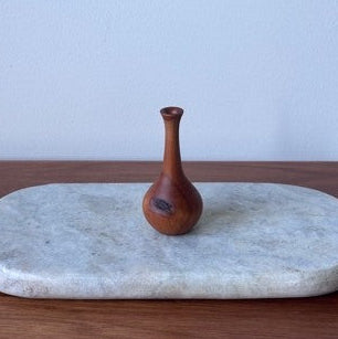 Marble tray with a wooden vase on a wooden surface