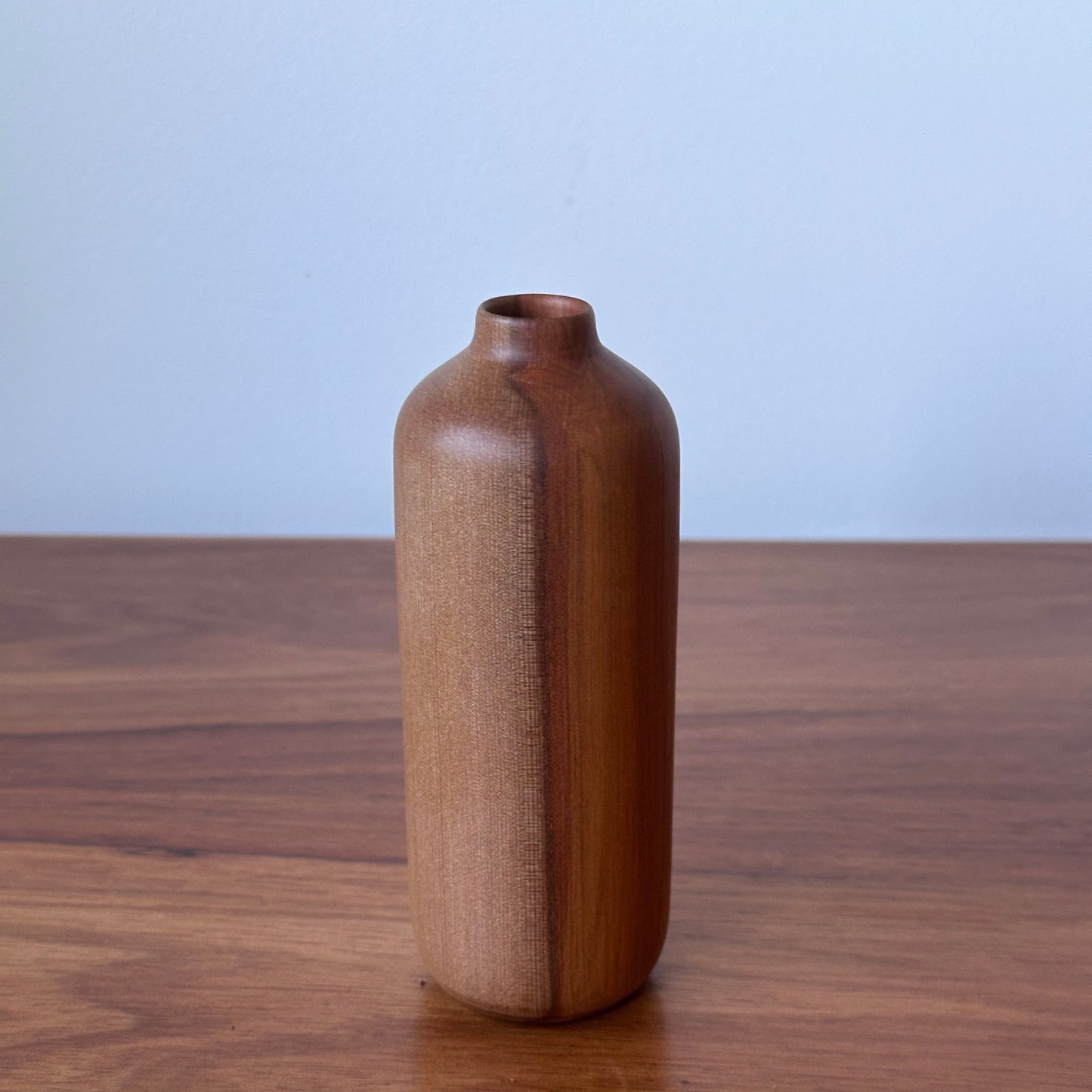Wooden handle on a wooden door with a light blue background