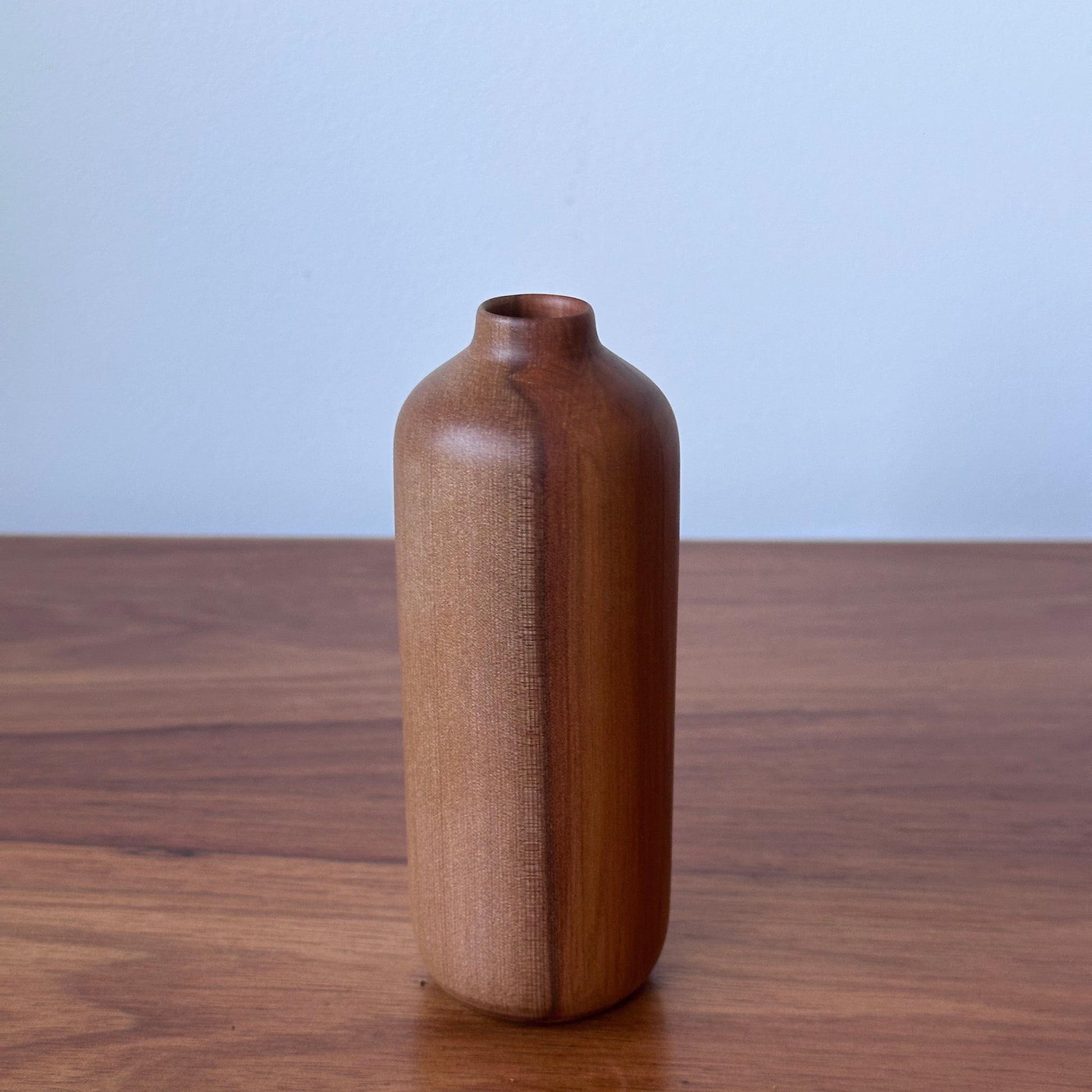 Wooden handle on a wooden door with a light blue background