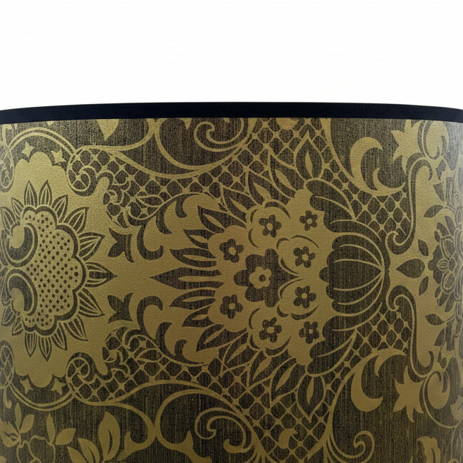 A close-up of a lampshade featuring a detailed black floral and scrollwork pattern on awhite background