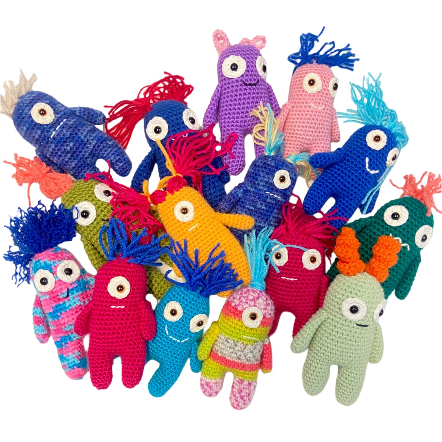 A collection of colorful handmade crochet worry monsters in various sizes and colors, each with a unique facial expression and hairstyle.