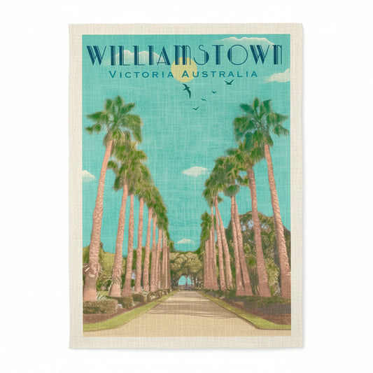 Person holding a tea towel with 'Williamstown, Victoria, Australia' design featuring palm trees.