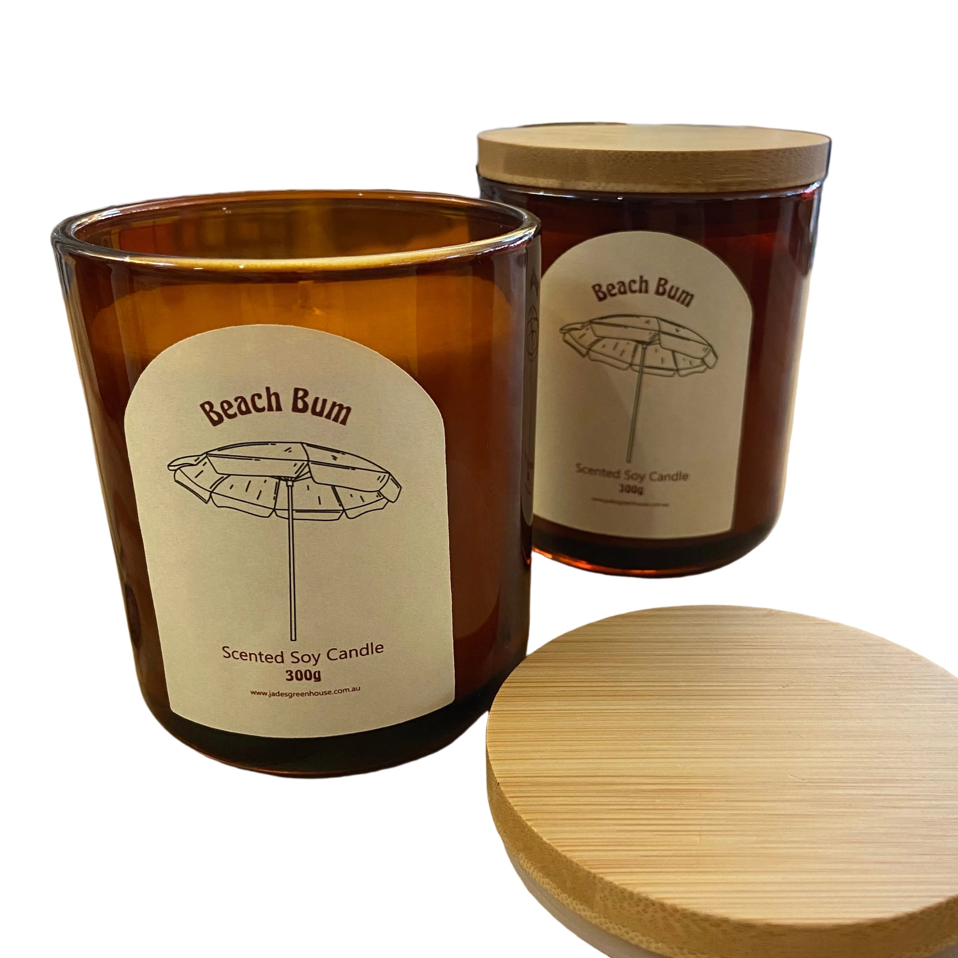 Two amber glass soy candles with bamboo lids on a wooden table inside a shop. One candle is open, showing the wax, and the other is closed.