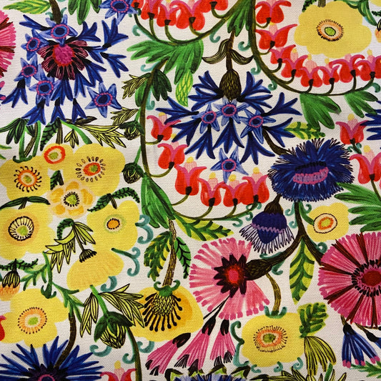 A close-up of the bleeding hearts fabric print featuring blue, pink, red, and yellow flowers with green leaves on a cream background.