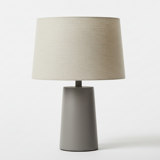 Table lamp with a beige shade and gray base on a white background