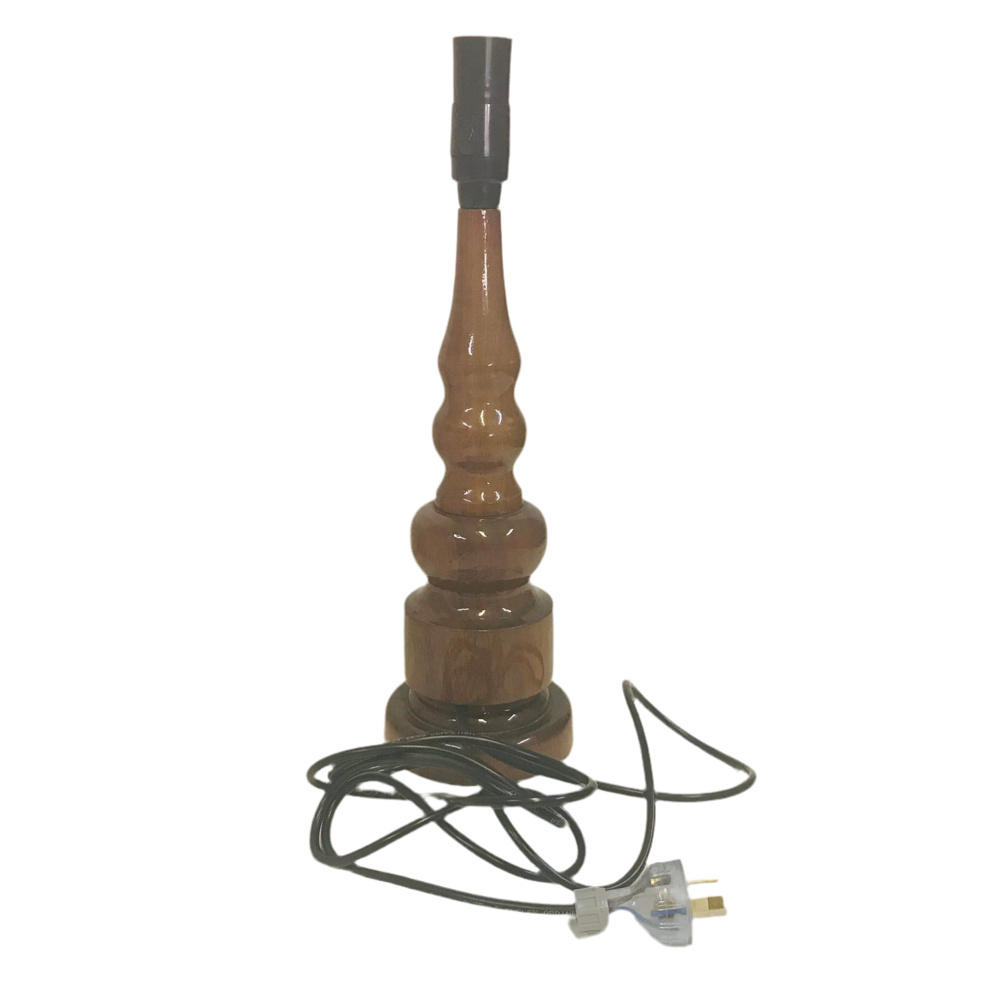 A lacquered handturned hardwood table lamp base with a cord and plug, displayed against a plain background.