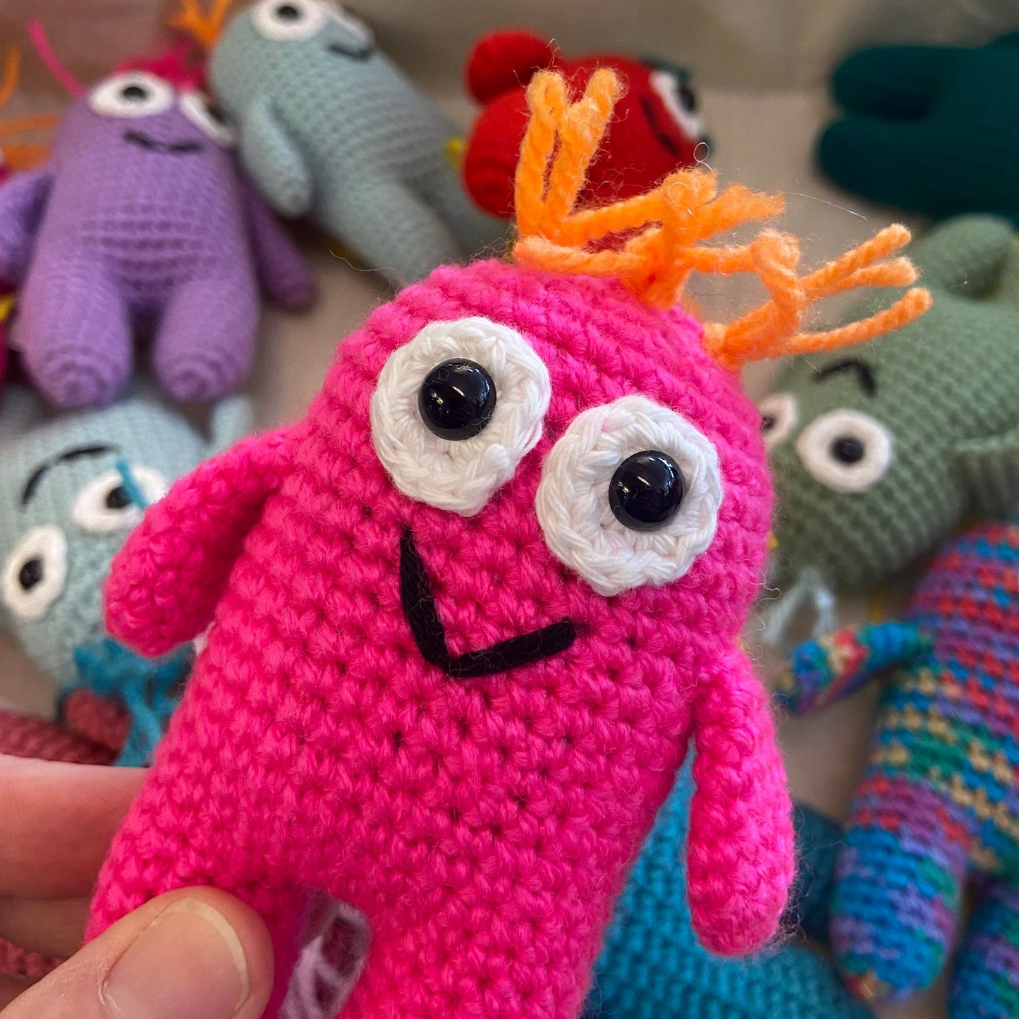 Colorful crochet monsters with a pink one in the foreground