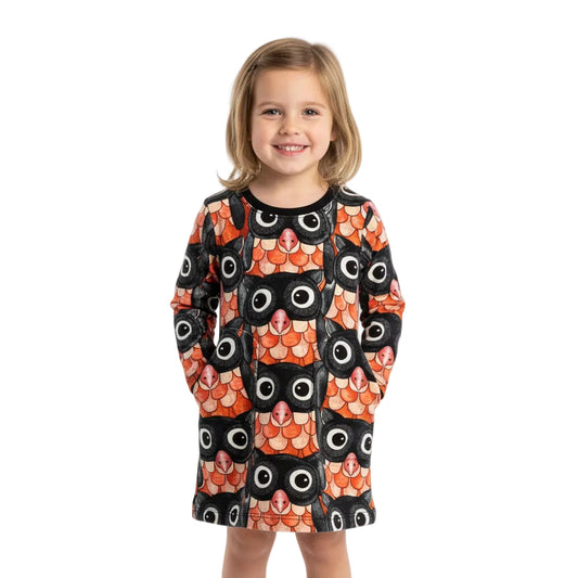 Young girl wearing a dress with a fish pattern on a white background