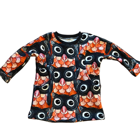 Children's long-sleeve shirt with owl pattern on a wooden floor