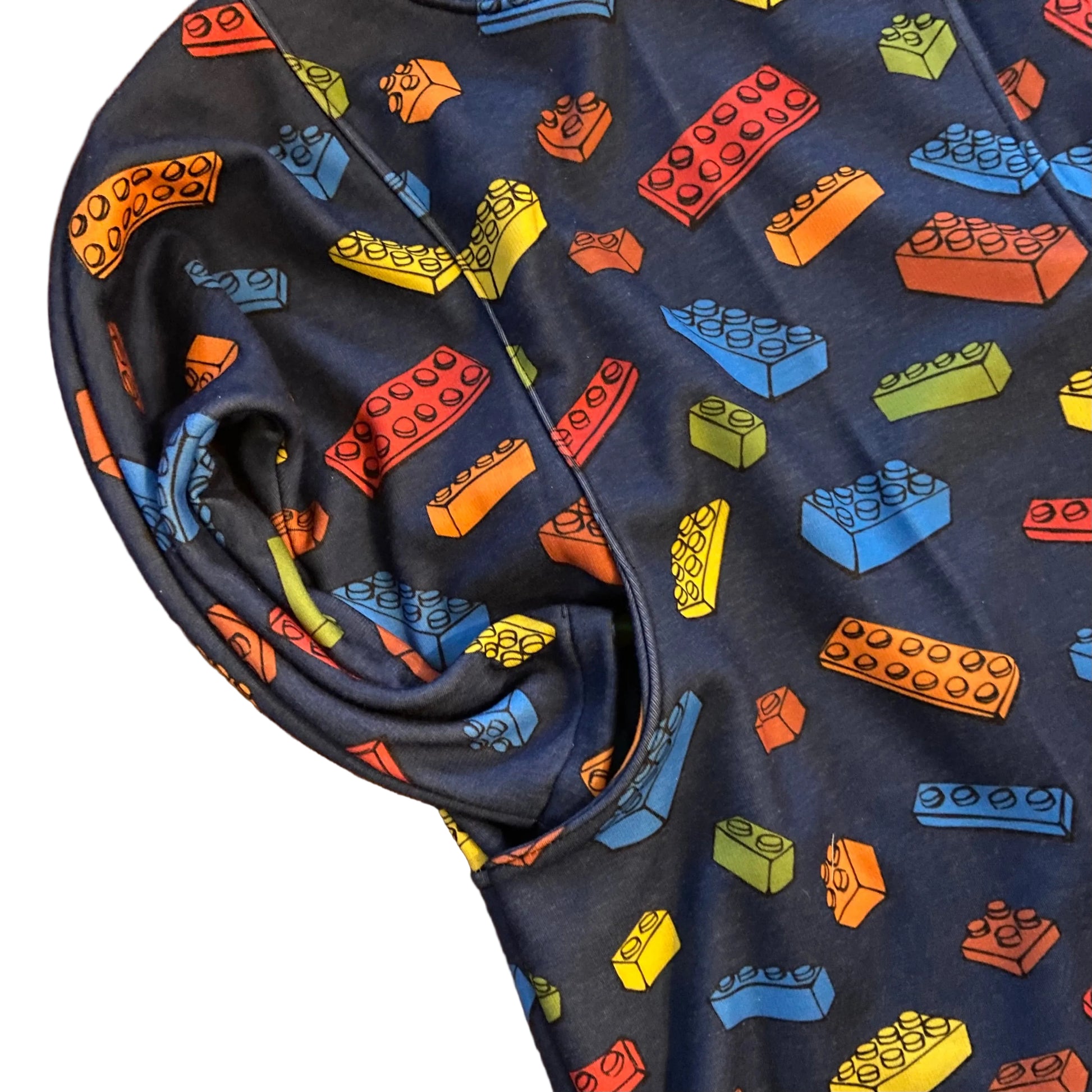 Navy blue fabric with colorful Lego block pattern on a wooden surface