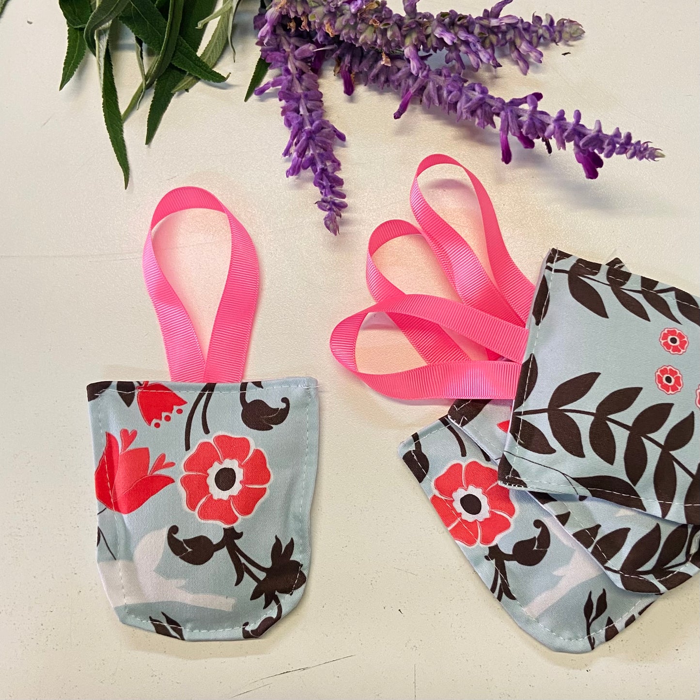 small hanging pouch filled with lavender to hang in your wardrobe or place in your clothing drawers to leave the space gmelling fresh. This set of four pouches have a blue, pink chocolate floral textile.